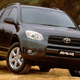 A photo of a black Toyota Rav4 SUV parked on dirt.